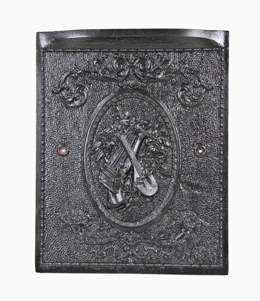 late 19th century black enameled ornamental cast iron interior residential fireplace summer cover with musical instrument assemblage