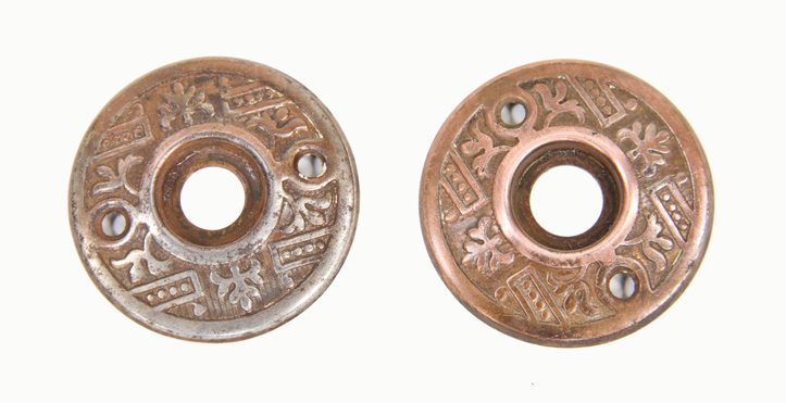 matching set of c. 1900's copper-plated ornamental stamped wrought steel residential doorknob rosettes