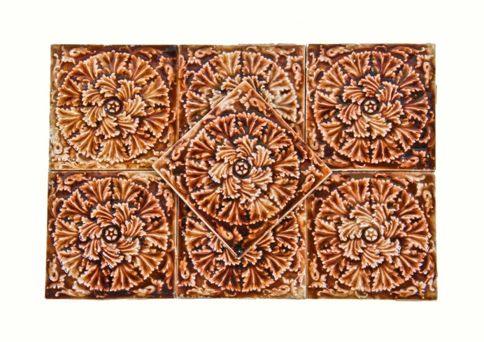group of seven matching american victorian era interior residential fireplace tiles with a floral swirl pattern