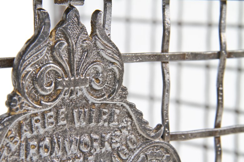 original late 19th century interior three-sided crimped steel square mesh bank teller cage with ornamental cast iron plaque