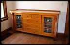 late 1920's american craftsman style interior residential varnished oak wood china cabinet or sideboard with art glass doors