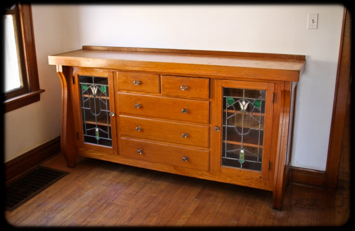 late 1920's american craftsman style interior residential varnished oak wood china cabinet or sideboard with art glass doors