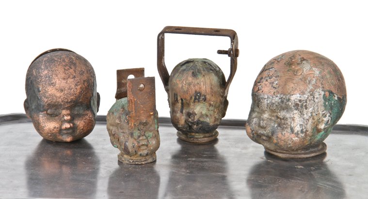 heavily coated vintage american industrial hollow copper doll head mold or form with stationary bent steel mounting bracket