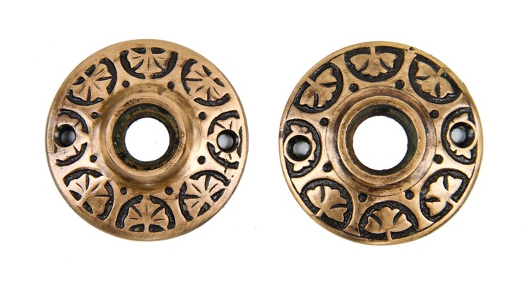 matching set of original antique american victorian era ornamental cast brass doorknob rosettes with a repeating floral motif