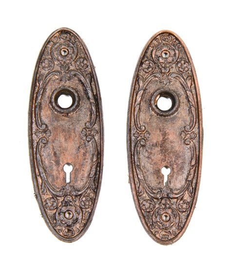 matching pair of early 20th century oval-shaped ornamental cast iron residential passage door escutcheons