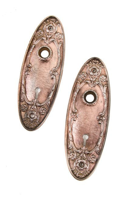 set of early 20th century ornamental cast iron copper-plated interior residential oval-shaped doorknob backplates