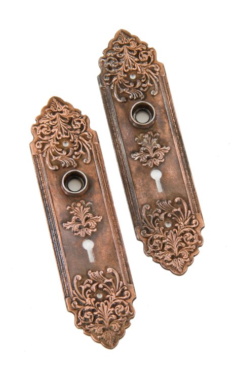 two matching c. 1900's american made antique ornamental cast iron interior residential doorknob backplates with copper-plated finish