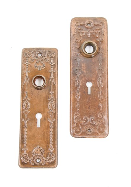 set of early 20th century american copper-plated stamped steel interior residential passage door escutcheons with embossed ornament