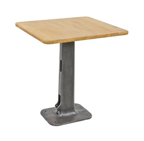 repurposed vintage american industrial pub table with old cast iron foot-operated riveter machine base and rounded edge wood tabletop