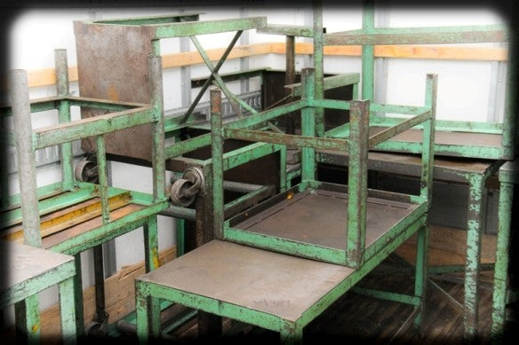 nice-sized original and robust factory green enameled all-welded joint stationary factory machine shop table with a mostly uniform brushed metal finish sealed with a clear coat lacquer