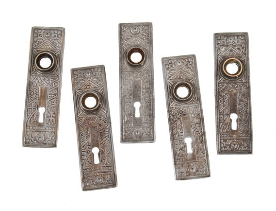 five matching early 20th century antique american ornamental wrought steel "ceylon" pattern interior residential doorknob backplates with single keyholes