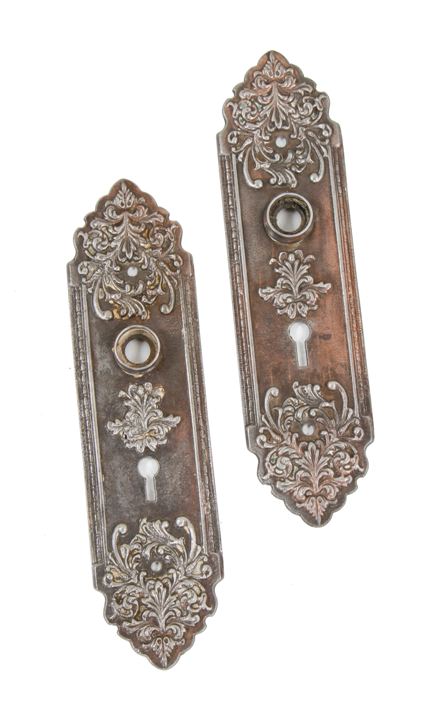 two matching original early 20th century american deeply embossed ornamental cast iron residential passage door backplates with copper-plated finish