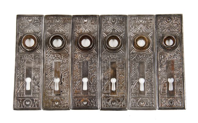 group of six matching antique american eastlake style heavy gauge stamped steel "ceylon" pattern residential doorknob backplates