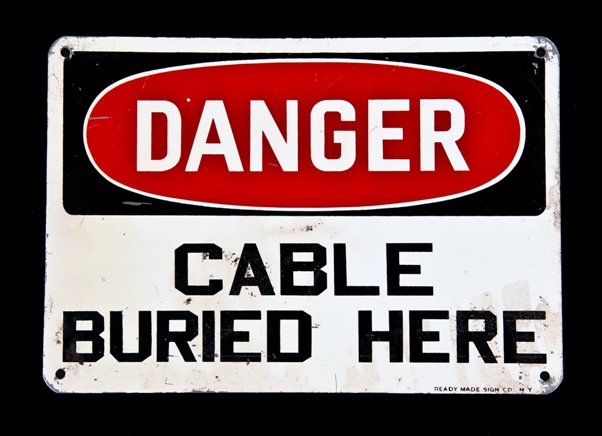 original c. 1950's vintage american industrial single-sided baked enameled die cut steel "cable buried here" warning or danger sign