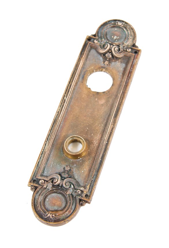 original early 20th century ornamental cast bronze exterior doorknob backplate or escutcheon with fanciful volutes and protruding thimble or collar