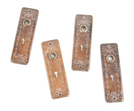 group of four matching c. 1910-20 american antique interior residential stamped steel doorknob backplates or escutcheons with copper-plated finish