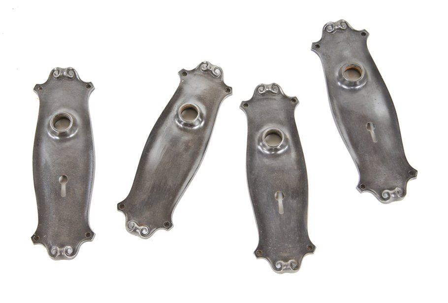 set of four matching early 20th century antique american refinished ornamental cast iron passage door backplates accentuated with volutes