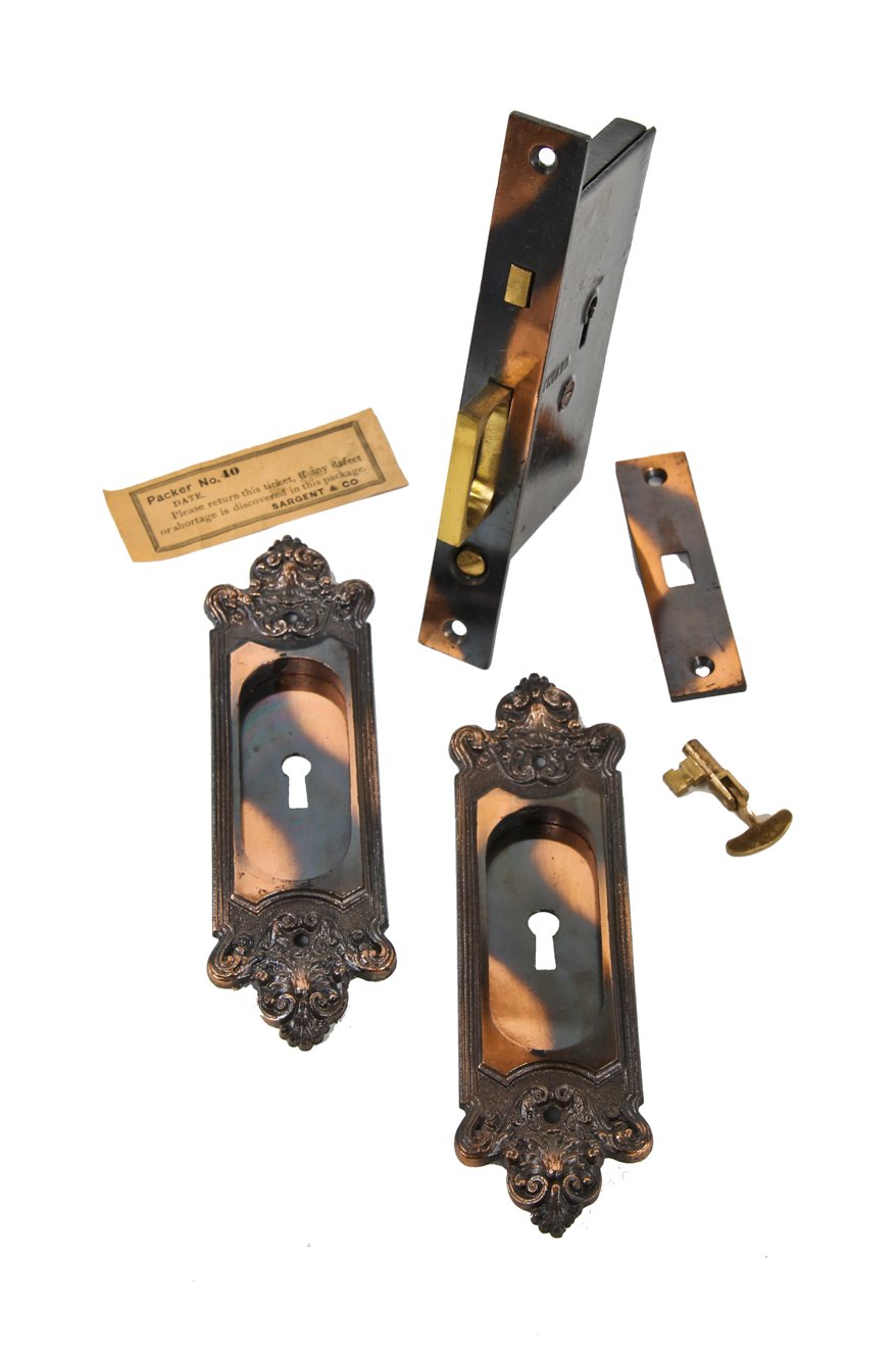 pristine early 20th century "new old stock" ornamental cast iron oxidized copper-plated single pocket door hardware with original box