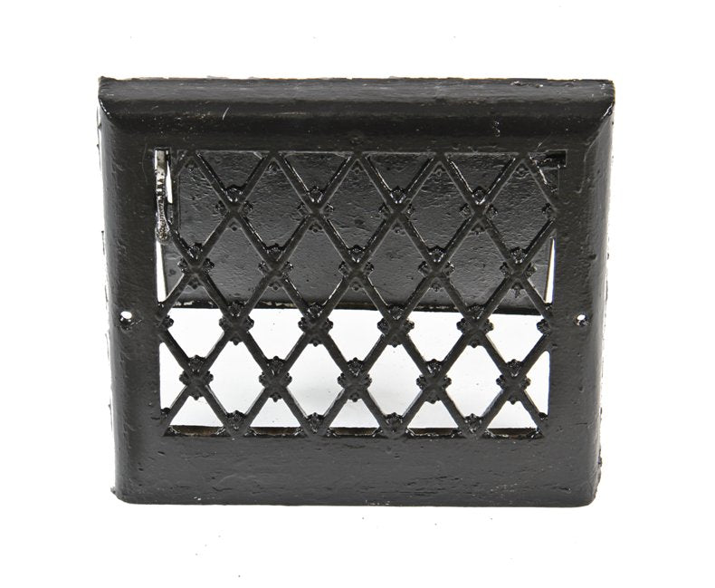 original early 20th century black enameled ornamental cast iron lattice patterned residential baseboard heat register with louver