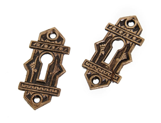two matching original 19th century ornamental cast bronze "oriental" pattern flush mount passage door keyhole escutcheons