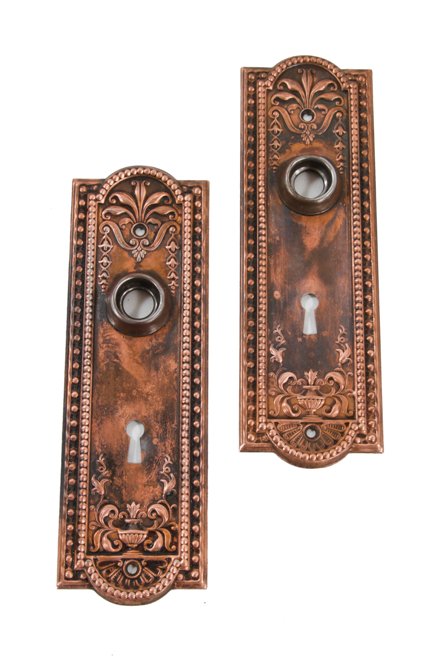 two matching original antique american "como" pattern interior residential doorknob backplates with copper-plated finish