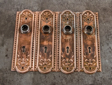 group of four original early 20th century antique american "como" pattern interior residential stamped steel doorknob backplates