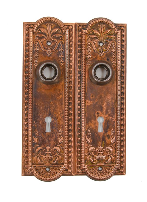 two early 20th century original and intact american antique ornamental copper-plated wrought steel "como" pattern doorknob backplates