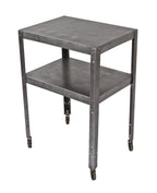 fully functional american industrial utilitarian pressed and formed steel four-legged two tier mobile cart with original hardened rubber casters