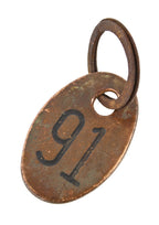 double-sided original american industrial wrought brass oval-shaped cow or cattle identification tag with nicely aged patina