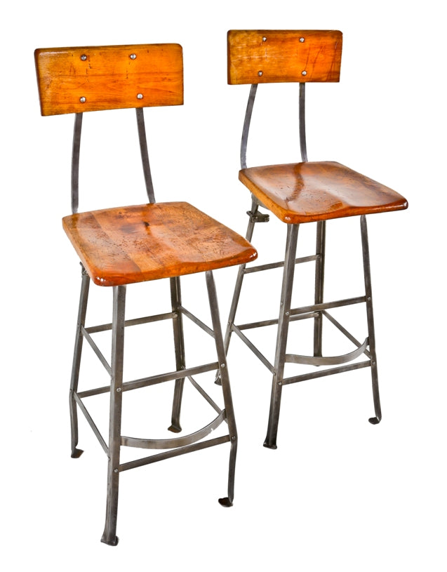 two matching very well-built c. 1930's original antique american industrial assembly line factory worker riveted joint angled steel refinished stools with maple wood seats and backrests