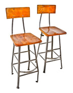 two matching very well-built c. 1930's original antique american industrial assembly line factory worker riveted joint angled steel refinished stools with maple wood seats and backrests