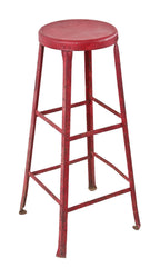 nicely weathered and worn oversized red painted heavy gauge riveted joint steel factory machinist stool with multiple stretchers and inward-turned ball feet