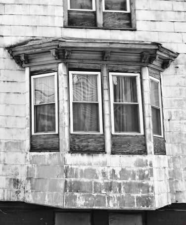 single diminutive early 1860's original antique american italianate style painted pine wood exterior residential bay window denailed bracket or corbel