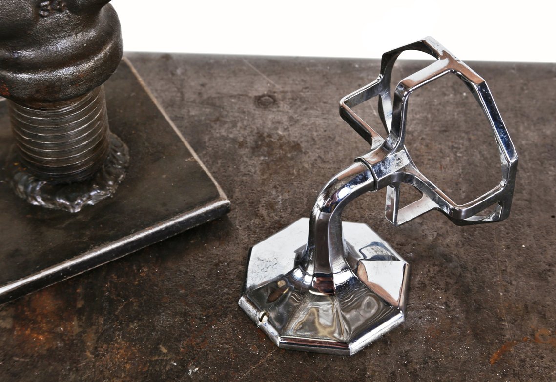 original polished chrome plated metal flush mount interior residential lavatory or washroom cup holder with distinctive multifaceted backplate