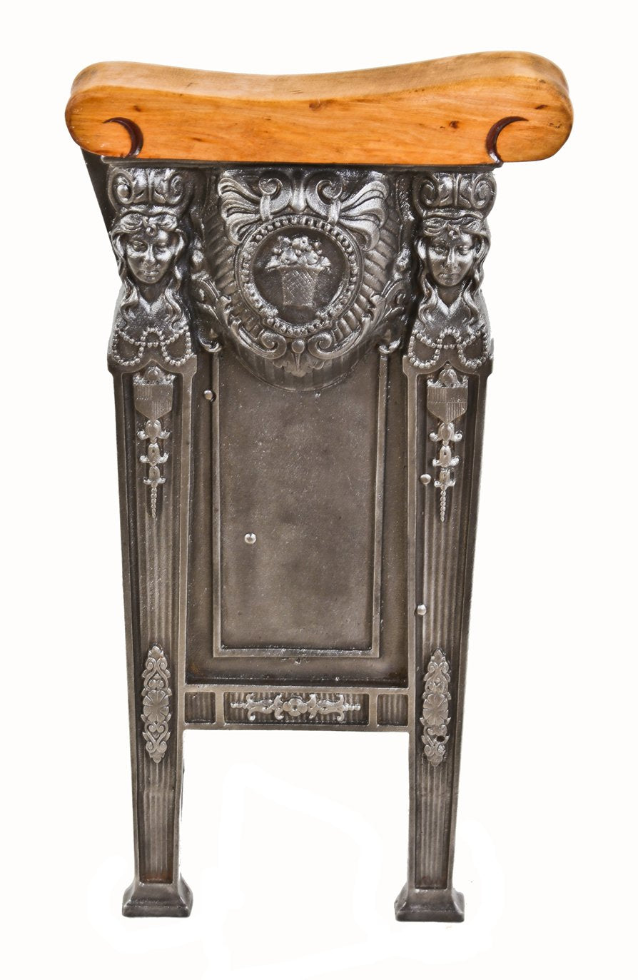 refinished original c. 1920's freestanding heavily ornamented cast iron theater seat end with solid birch wood set rest and opposed female faces with flowing hair