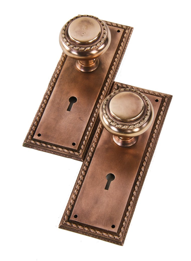 refinished turn of the century antique american ornamental cast bronze interior residential matching doorknobs and backplates with decorative borders