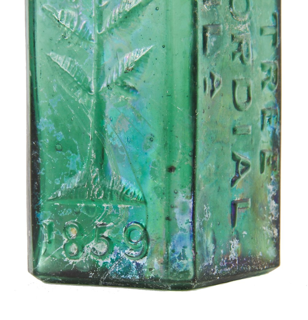 original early 1860's skillfully crafted emerald green hand-blown "pine tree tar cordial" dug bottle with pontil scar and slanted neck containing vertical straw marks ans seeds