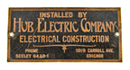 original american depression-era single-sided stamped brass paradise theater (non-extant) hub electric manufacturer plaque with black enameled background