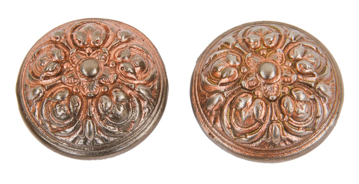 two mating deeply embossed ornamental cast iron interior residential passage door banded rim doorknobs with traces of a copper-plated finish