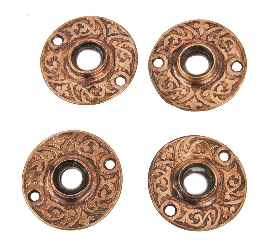 group of four matching original c. 1880's ornamental cast brass circular-shaped interior residential doorknob rosettes with foliated scrollwork throughout