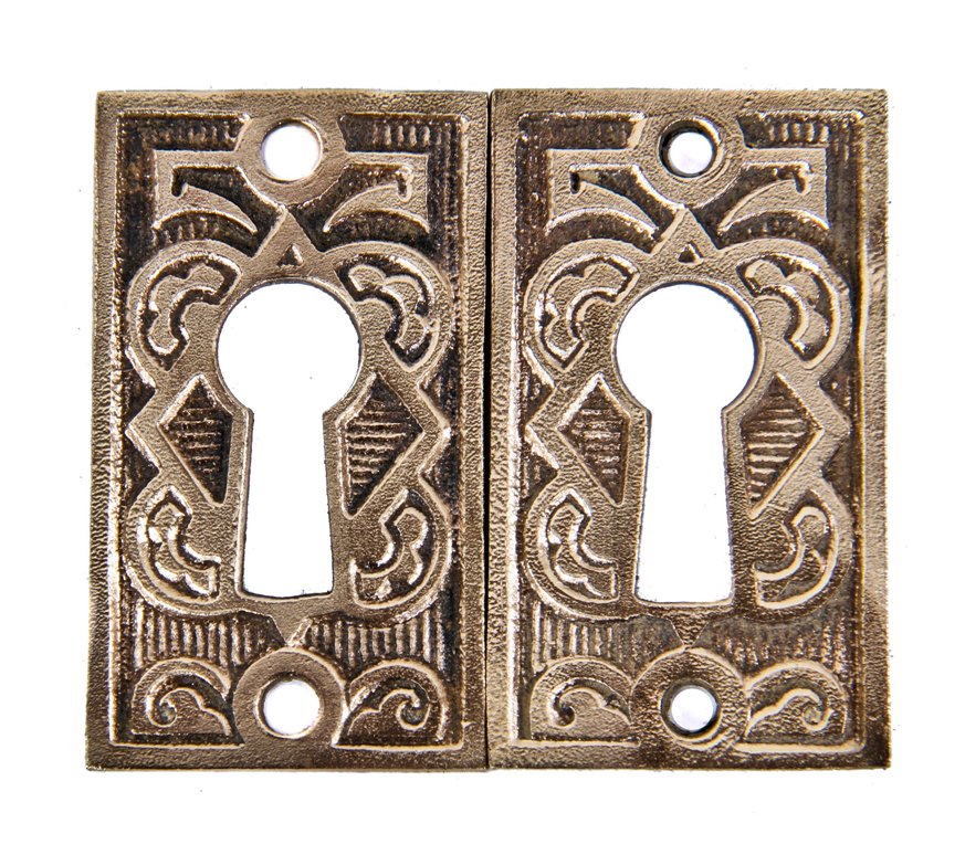 matching set of 19th century ornamental cast brass diminutive interior residential passage door keyhole escutcheons with a mostly uniform surface finish