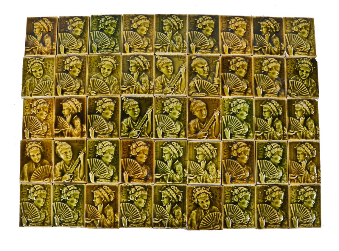 single 19th century yellow-brown majolica glazed intact residential parlor stove ceramic tile featuring a lightly embossed costumed geisha girl