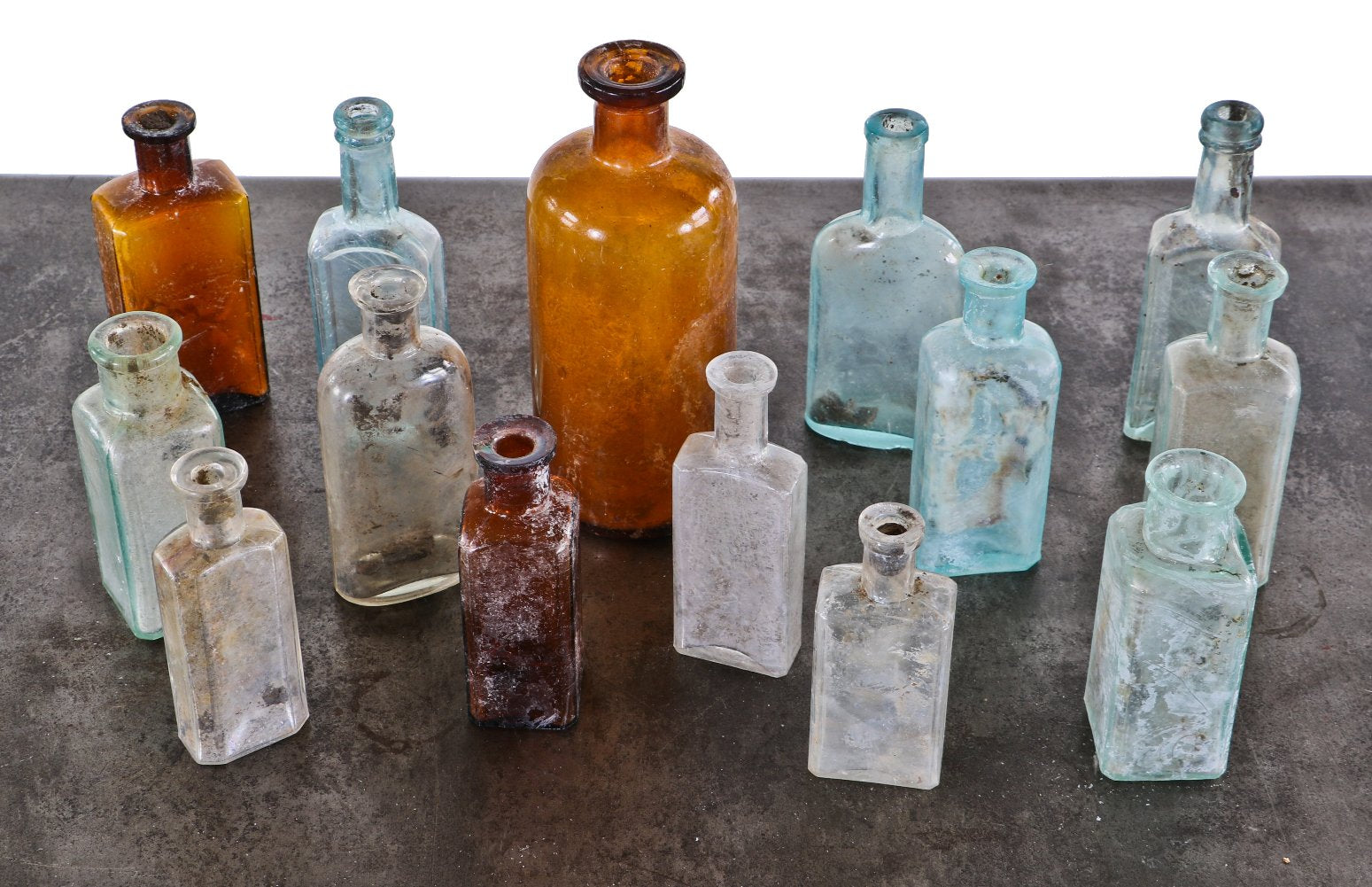 assortment of late 19th and early 20th century antique american "dug" chicago privy pit medicinal glass bottles in a variety of colors