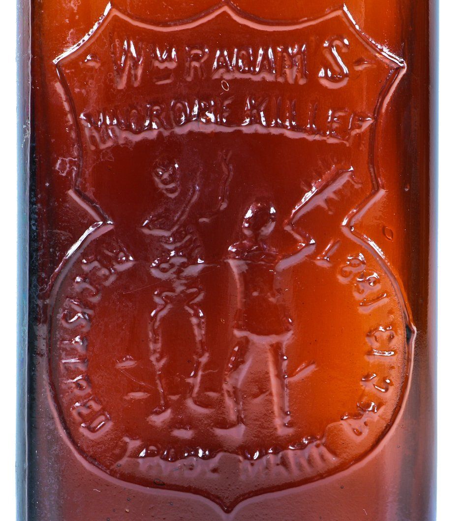 rare late 19th century antique american medical dark amber or brown glass "radam's microbe killer" embossed medicinal bottle with tooled plain lip