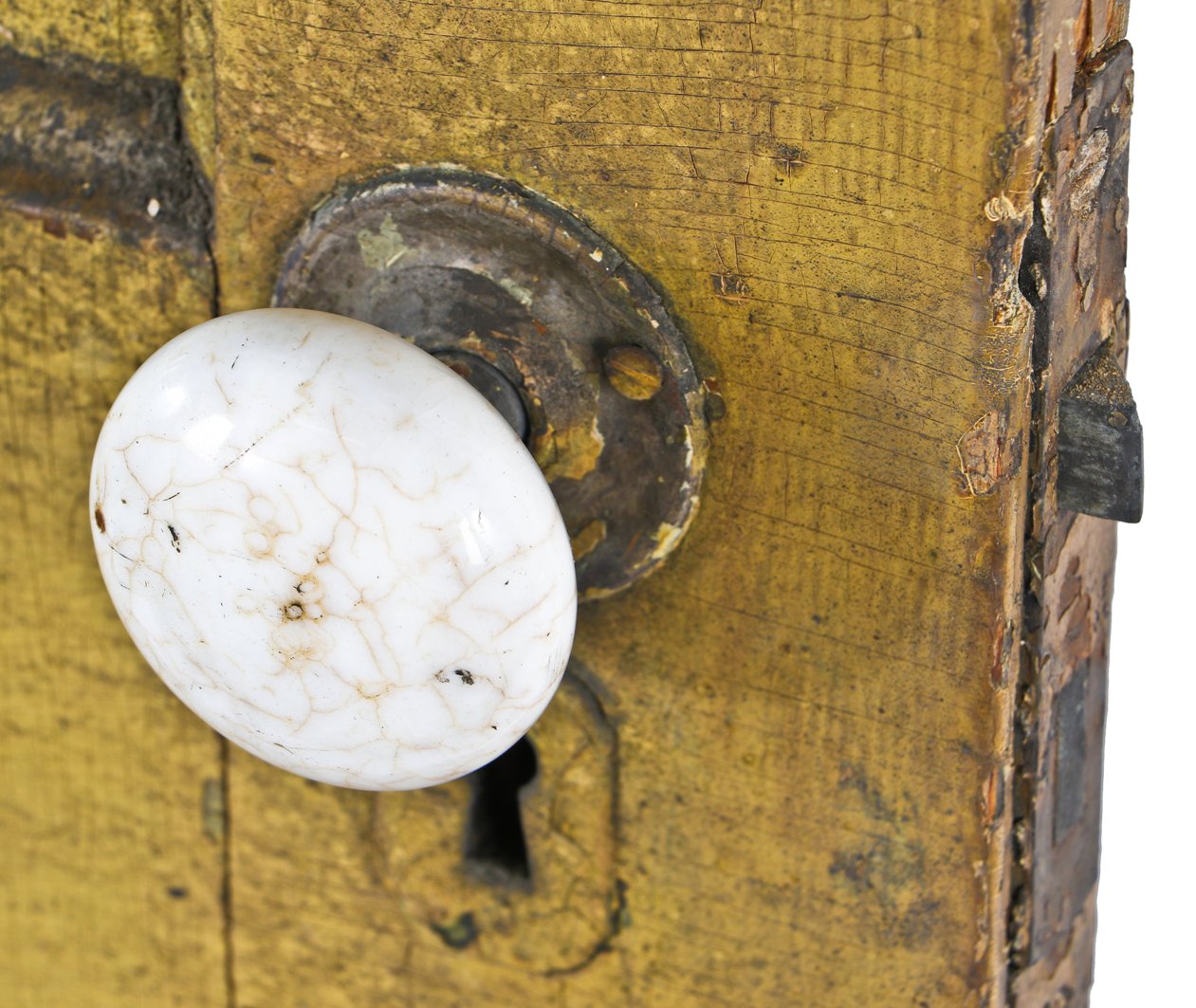 nicely worn and weathered old yellow painted pine wood pre-fire chicago four-panel door with original russell & erwin patented mortise lock and white porcelain doorknobs