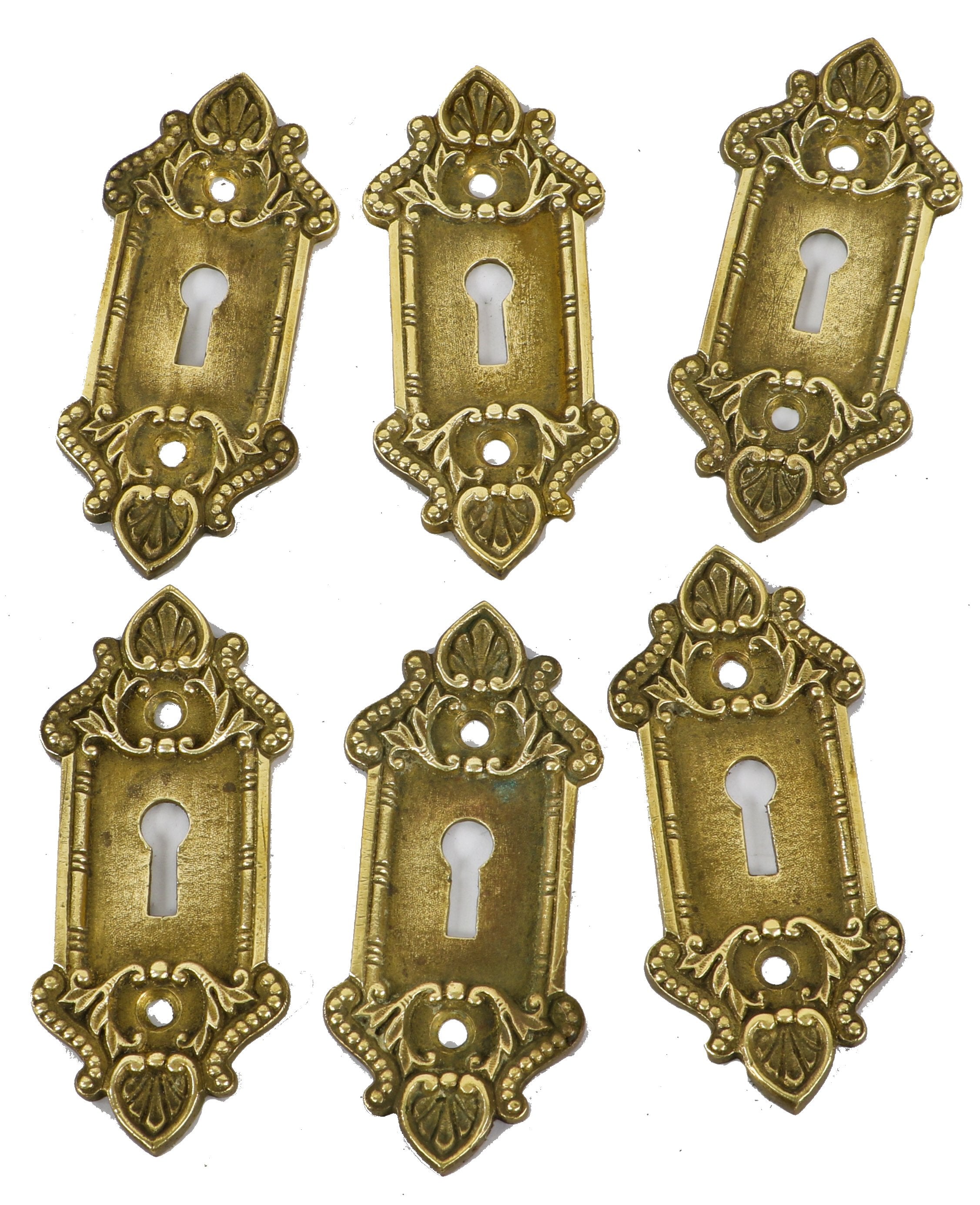 group of six matching late 19th or early 20th century heavy cast brass interior residential ornamental passage door keyhole escutcheons with nicely aged patina