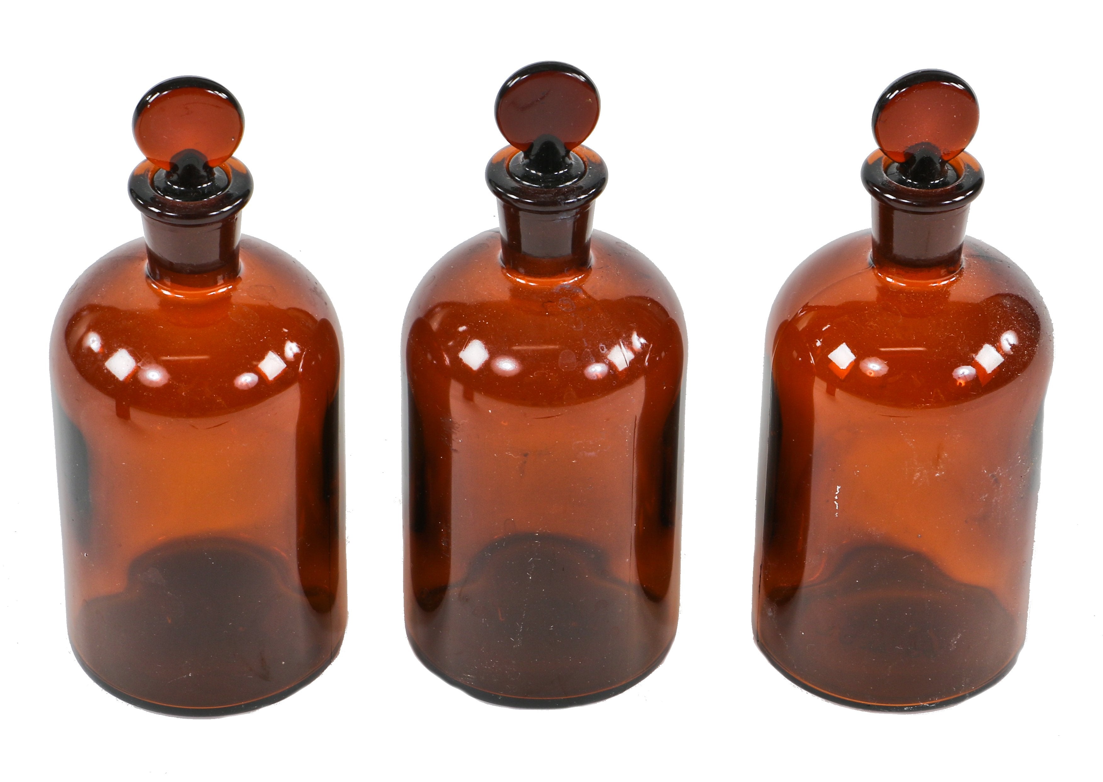 all original and intact c. 1940's matching lot of three american industrial dark amber glass research laboratory bottles with detachable "penny" style ground glass stoppers