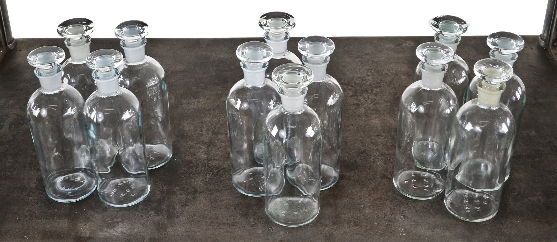 large group of matching original c. 1950's vintage industrial clear glass research laboratory reagent bottles with original oversized disc-shaped ground glass removable stoppers