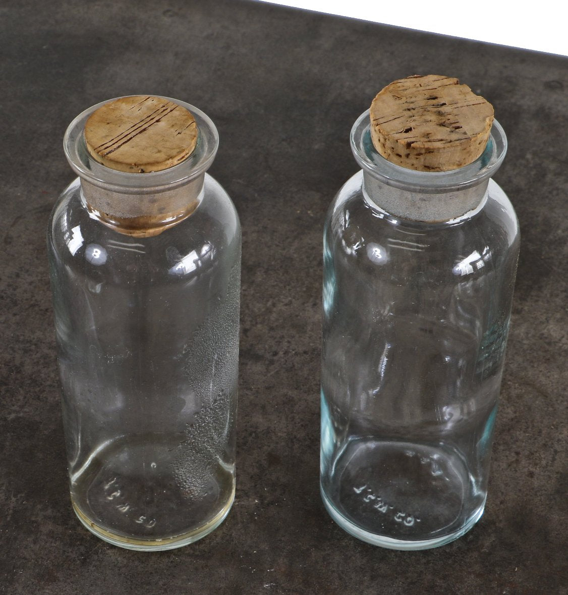 pair of original and intact vintage american industrial heavy duty clear glass american chemistry laboratory reagent bottles with oversized cork stoppers