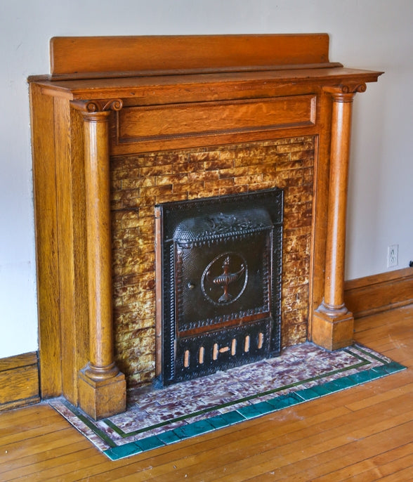 original well-maintained early 20th century varnished quartered oak wood interior residential front parlor fireplace mantel with solid round columns